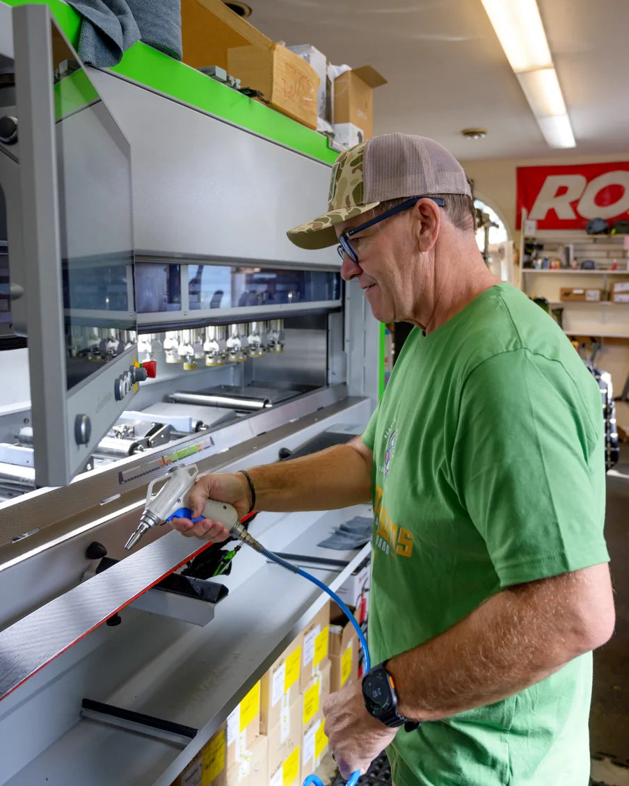 Ski technician tuning a ski using a tool